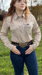 Woman wearing a striped shirt and jeans with a belt buckle outdoors